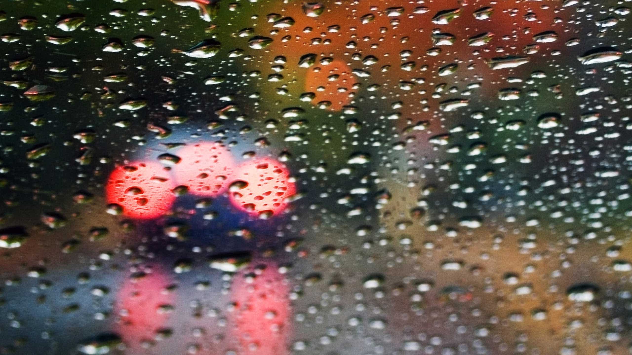 blurred rain drops on car gals with bokeh of light